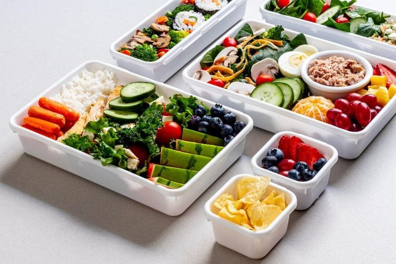 Colorful meatless meal prep with vegetables, grains, and legumes in containers, highlighting affordable and healthy plant-based eating.